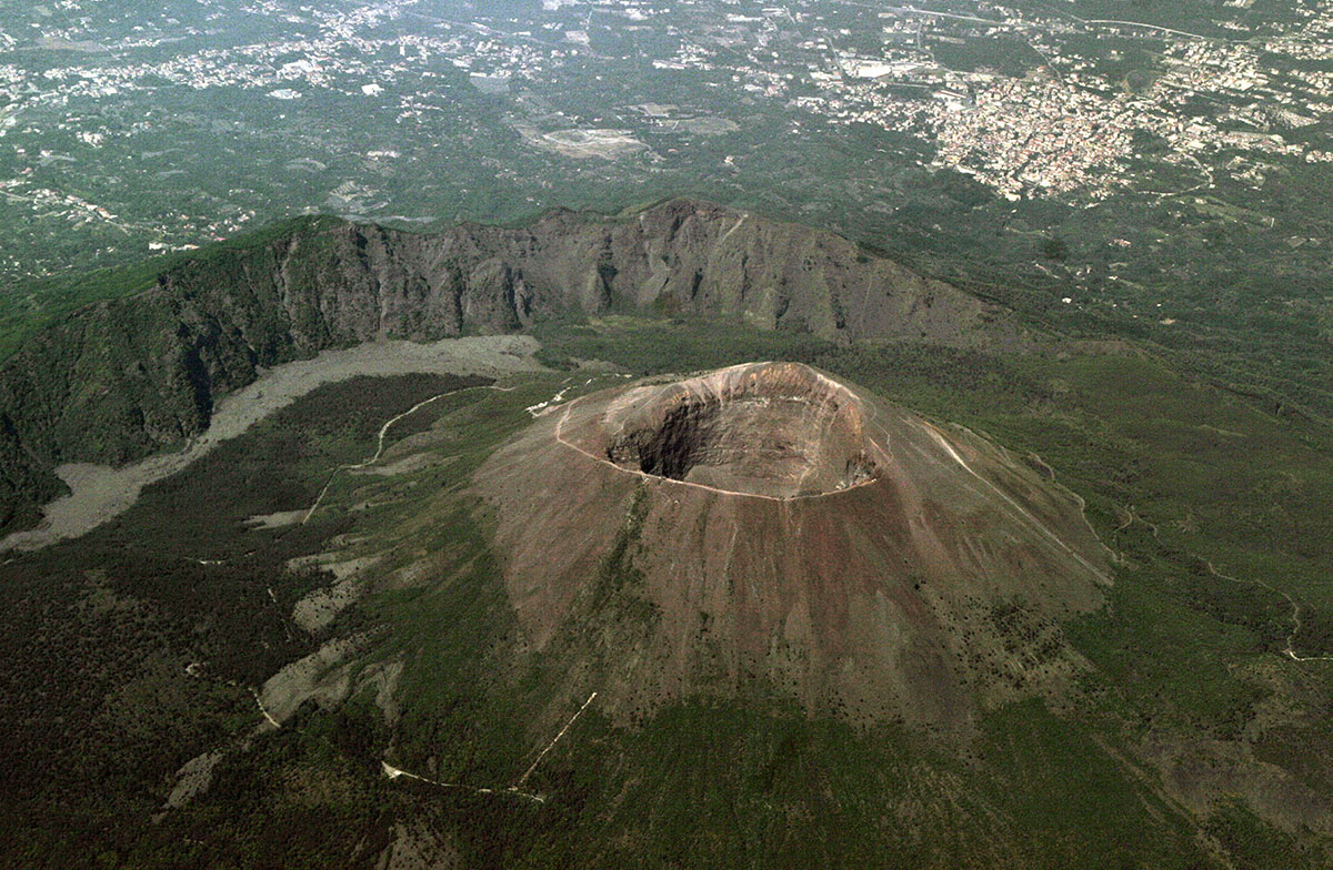 The modern cone of Vesuvius, with the somma rim of the huge, ancient volcano on upper left. Despite repeated catastrophic events, development has not slowed on the flanks of the volcano. (iStock.com / TatianaMironenko)
